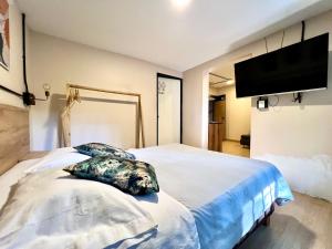 a bedroom with a large bed with a flat screen tv at Nuevo estudio cerca de Plaza Mayor NID101 By Roots Rentals in Medellín