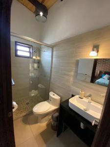 une salle de bain avec des toilettes blanches et un lavabo dans l'établissement Cabañas Rinconada Tapalpa, à San Antonio 13 autres photos