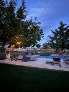 a pool with couches and chairs next to a tree at Espacio Shangrila.One in Uceda