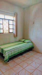 a bed in a corner of a room with a window at Apto com Estac Gratis e Conforto in Paragominas