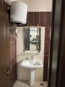 ein Badezimmer mit Waschbecken und Spiegel in der Unterkunft Résidence Corail in Arafat