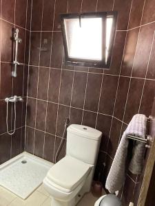 ein kleines Badezimmer mit Toilette und Fenster in der Unterkunft Résidence Corail in Arafat