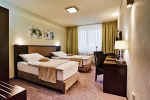 a hotel room with two beds and a desk at Privilege - EMPIRE Hotels Group in Košice +34 photos