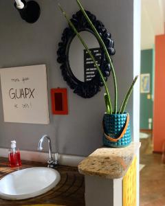 a bathroom with a sink and a mirror and a potted plant at neighbor.HUB hostel & coliving FLORIPA in Florianópolis +58 photos
