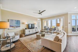 a living room with a couch and a tv at 4 Collier Beach Rd- Oceanfront, Private Pool, Elevator, FREE Activities Included in Hilton Head Island