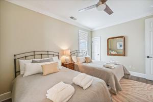 a bedroom with two beds and a mirror at 4 Collier Beach Rd- Oceanfront, Private Pool, Elevator, FREE Activities Included in Hilton Head Island +43 photos
