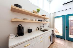 a kitchen with white cabinets and a sink at Cozy and Bright Mid-Century Gem in Eastside Action in Austin +3 photos