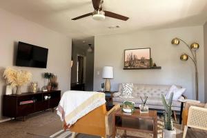 a living room with a couch and a ceiling fan at McKinley House Prime - Pool, Patio and Garage in Amarillo