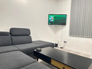 a living room with a couch and a flat screen tv at 8-Sleeper 4BR 4Bed 2Bath Wi-Fi Garden Tv Beach in Portsmouth