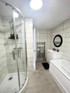 a white bathroom with a shower and a sink at 8-Sleeper 4BR 4Bed 2Bath Wi-Fi Garden Tv Beach in Portsmouth