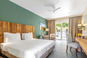 a bedroom with a large bed and a desk and chair at Bayside Boutique Hotel - Blue Bay Golf & Beach Resort in Willemstad +48 photos