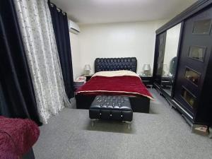 a bedroom with a bed with a red blanket on it at Ambassador INN in Tufailah