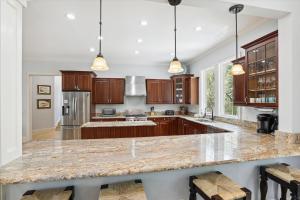 a kitchen with wooden cabinets and a marble counter top at 4 Surfwatch Way- Pet Friendly, Pool & Spa, Short Walk To Beach! FREE Activities Included in Hilton Head Island