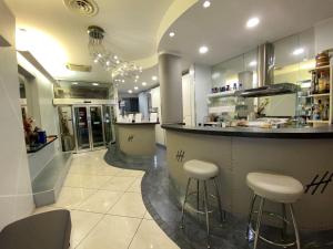 a kitchen with a bar with stools in a restaurant at Hotel Holiday- Alla Finestrella in Bologna