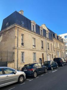 a row of cars parked in front of a building at Appartement Caen théâtre in Caen
