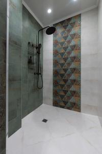 eine Dusche mit Glastür im Badezimmer in der Unterkunft Домът на Билкарката in Plowdiw