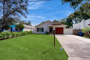 a house with a grass yard and a driveway at Bayside Bungalow in Tampa