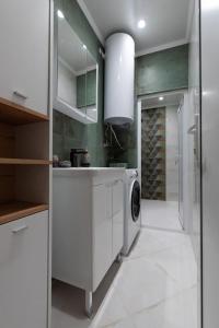 eine weiße Küche mit Waschmaschine in der Unterkunft Домът на Билкарката in Plowdiw