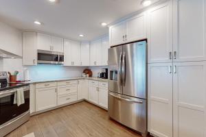 a kitchen with white cabinets and a stainless steel refrigerator at Bayside Bungalow in Tampa