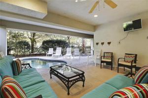 sala de estar con sofá, mesa y piscina en 5 Henry Lane- Near Ocean, Private Pool, Pet Friendly, FREE Activities Included, en Hilton Head Island