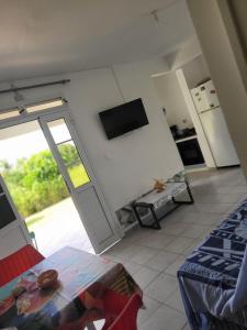 a room with a living room with a tv on the wall at StudioLyne in Capesterre