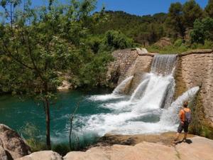 a man standing in front of a waterfall at Casa Ríos in El Burgo