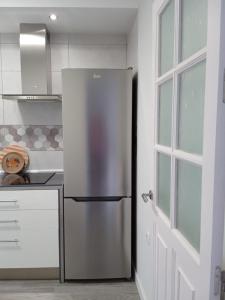 a stainless steel refrigerator in a kitchen next to a door at Casa Ríos in El Burgo +14 photos