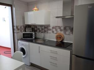 a kitchen with a sink and a washing machine at Casa Ríos in El Burgo