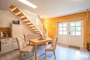 a dining room with a table and chairs and a staircase at Ferienwohnungen an der Hauptspree in Kolonie +46 photos