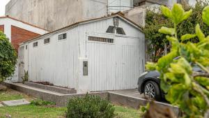 利马Beach Cabin Getaway的前面有一个停车场的白色车库