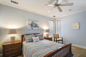 a bedroom with a bed and a ceiling fan at 6 Collier Beach Road- Oceanfront, Large Pool, Elevator, FREE Activities Included in Hilton Head Island +58 photos