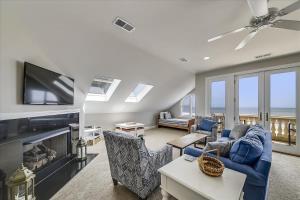a living room with a blue couch and a tv at 6 Collier Beach Road- Oceanfront, Large Pool, Elevator, FREE Activities Included in Hilton Head Island