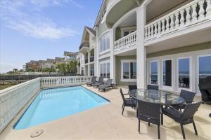 a house with a swimming pool and a table and chairs at 6 Collier Beach Road- Oceanfront, Large Pool, Elevator, FREE Activities Included in Hilton Head Island