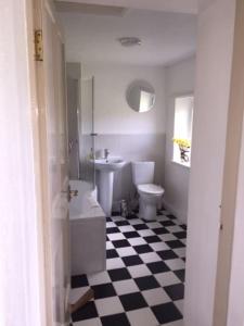 a bathroom with a black and white checkered floor at FREE HOT TUB use, Exclusive Idyllic Large Themed Cumbrian Mill Countryside 100s 5star most loved in Carlisle +70 photos