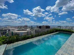 una piscina in cima a un edificio con vista sulla città di Condomínio completo, vaga de Garagem e Conforto a 50m do Allianz Parque a San Paolo