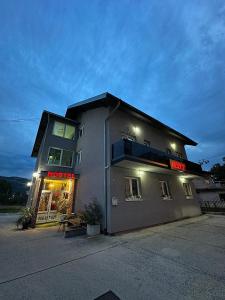 a building with a neon sign on the side of it at Hostel Herz in Banja Luka +58 photos