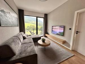 a living room with a couch and a large window at Apartmán NOEL Terchová in Terchová