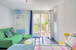a living room with a green couch and stool at Paris Orly Metro 7 et 14 in Villejuif