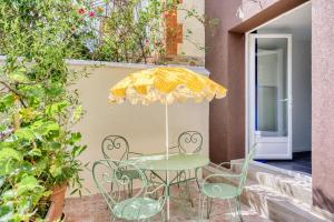 a table and chairs with an umbrella on a patio at Paris Orly Metro 7 et 14 in Villejuif