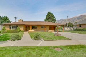 a yellow house with a driveway in front of it at Walk to Downtown Brigham City Family Home in Brigham City