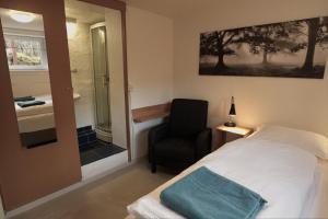 レイキャビクにあるMain street X-small, ensuite bathroom and own kitchenのベッドと椅子と窓のある寝室 +1枚の写真