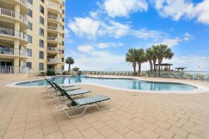 a swimming pool with lounge chairs and a resort at Beach Colony West 1C in Pensacola