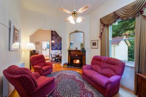 a living room with two chairs and a fireplace at Charnwood Cottages in Warburton in Warburton