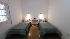 een hal met 2 bedden in een kamer met een raam bij Departamento SD in La Rioja