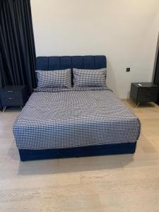 クアラルンプールにあるHoliday Suites Star Residencesのベッド1台(白黒の掛け布団、ナイトスタンド2台付)