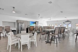 a room with tables and chairs and a kitchen at Gated Oceanfront Heated Pool in Marathon