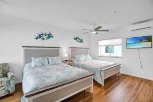 a bedroom with two beds and a ceiling fan at Green Turtle Retreat at Ocean Isles in Marathon +29 photos