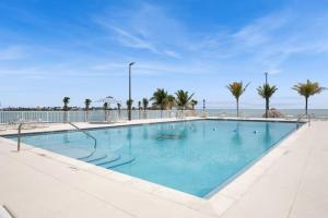 a large swimming pool with palm trees and the ocean at Ocean Isles Mackeral Row in Marathon