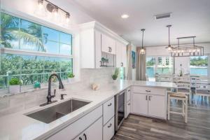 a kitchen with white cabinets and a large window at Oceans Edge Retreat in Key Colony Beach