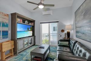 a living room with a couch and a flat screen tv at Oceanside Spacious Studio Escape in Marathon